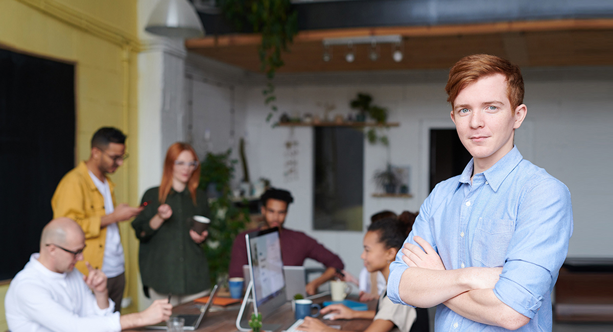 man-standing-beside-people-sitting-beside-table-with-laptops-31843951.jpg